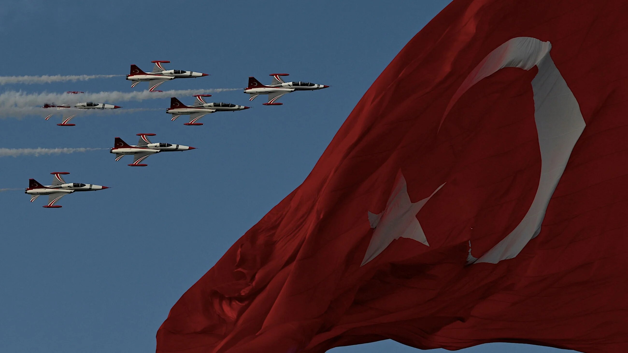 Turkish Air force pilots of the 'Turkish Stars' fly in Northrop F-5 near a national flag to mark the 100th anniversary of Turkish Republic in Istanbul on October 29, 2023 (AFP)