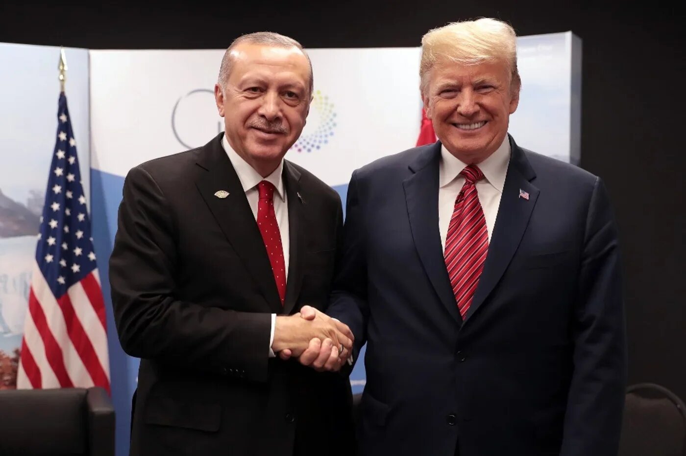 A handout picture released by the Turkish Presidential Palace Press Office shows Turkey's President Recep Tayyip Erdogan (L) posing with US President Donald Trump during the G20 summit in Buenos Aires, Argentina, on 1 December 2018 (AFP)