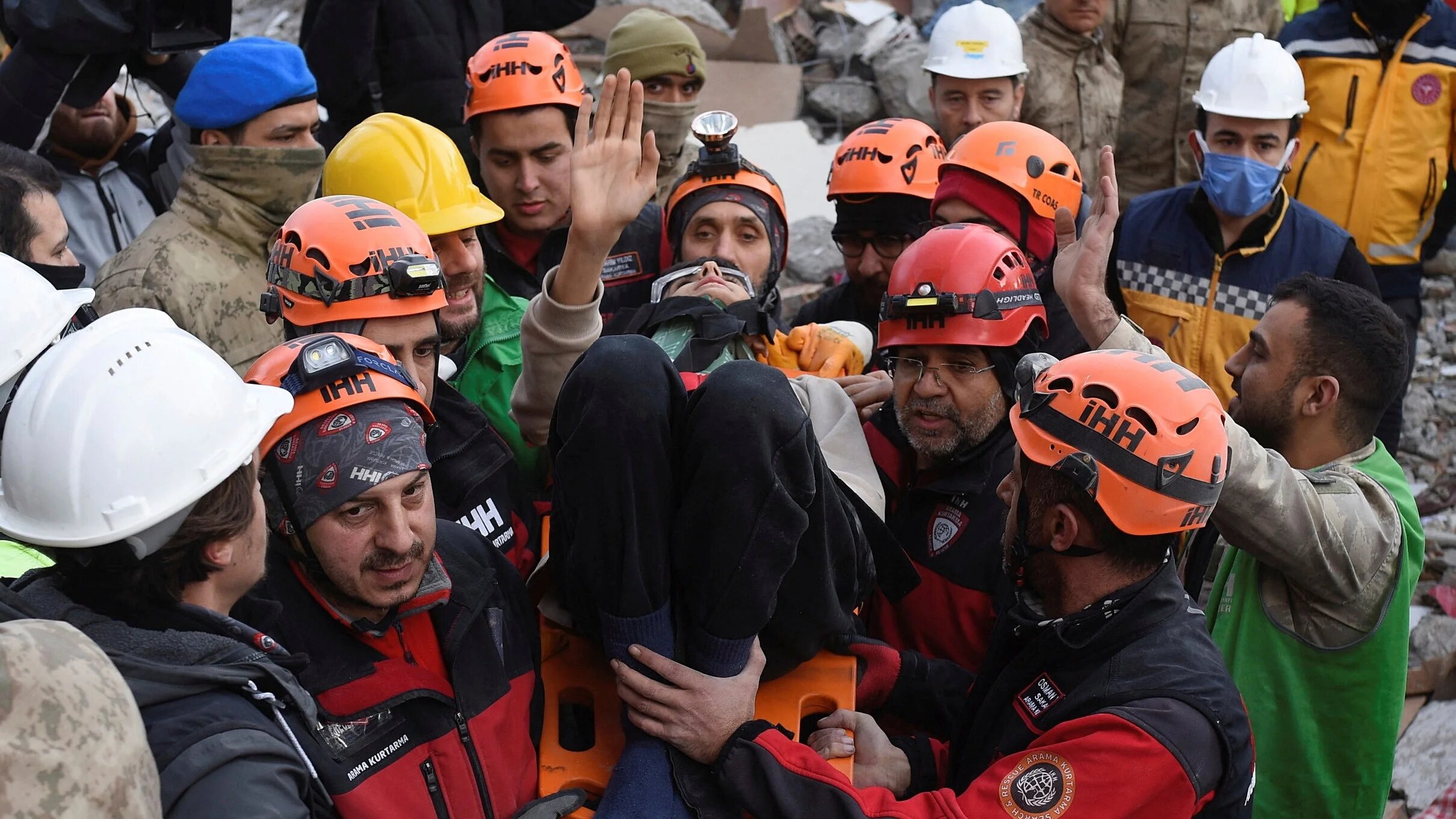 A man waves after being rescued alive from rubble, in the aftermath of a deadly earthquake in Iskenderun, Turkey on 10 February 2023 (Reuters)
