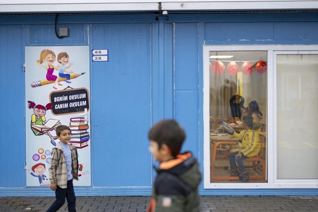 Des enfants reçoivent leurs bulletins scolaires dans une école-conteneur de Kahramanmaraş, le 19 janvier 2024 (AFP/Yasin Akgül)