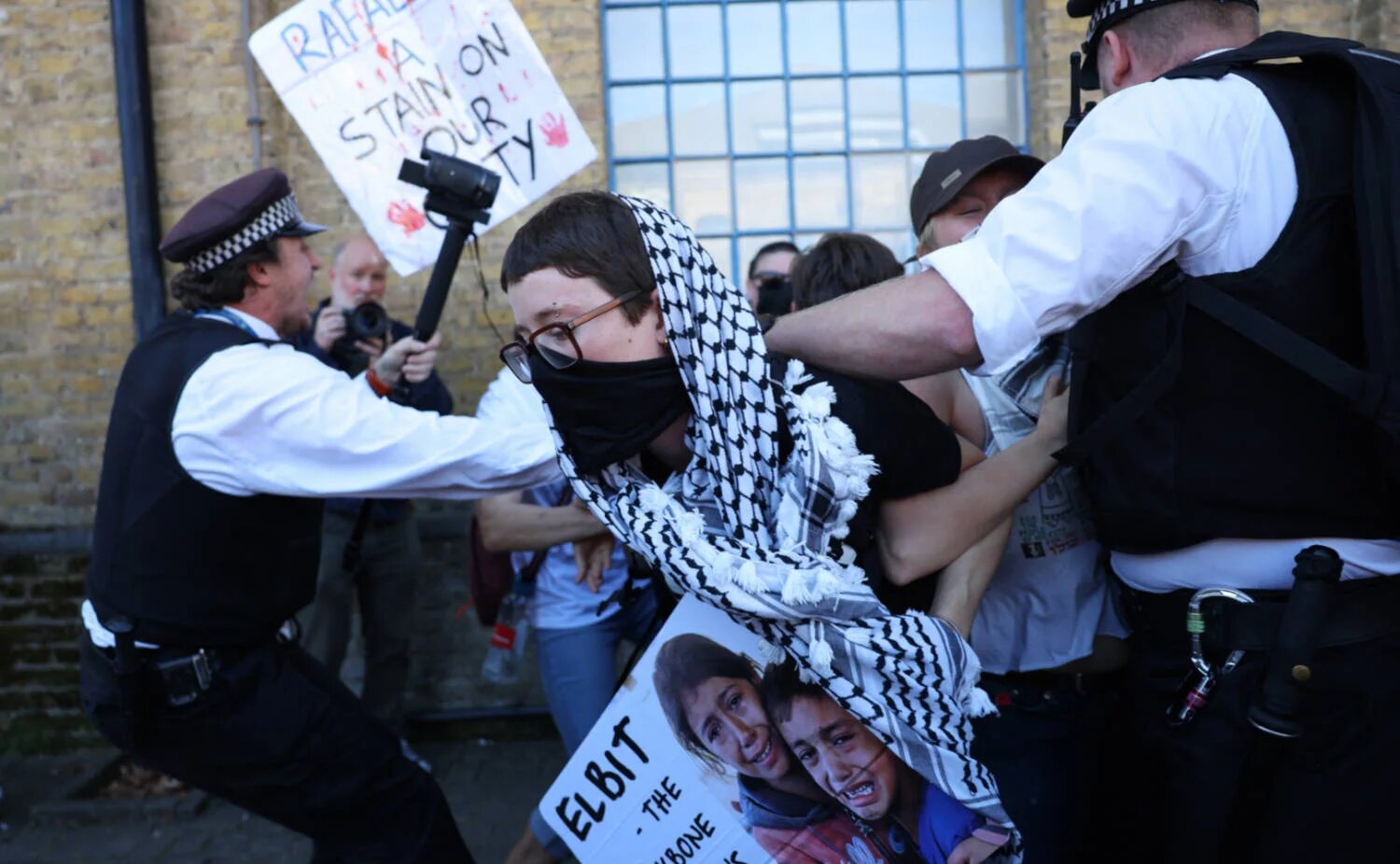 Demonstrators protest outside the entrance to the Defence and Security Equipment International (DSEI) fair at the ExCeL centre, London, on 9 September 2025 (AFP)