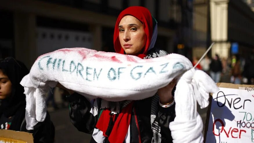 A protester holds a shroud reading “Children of Gaza” as pro-Palestinian activists gather for a demonstration in central London on 30 March 2024 (Benjamin Cremel/AFP)