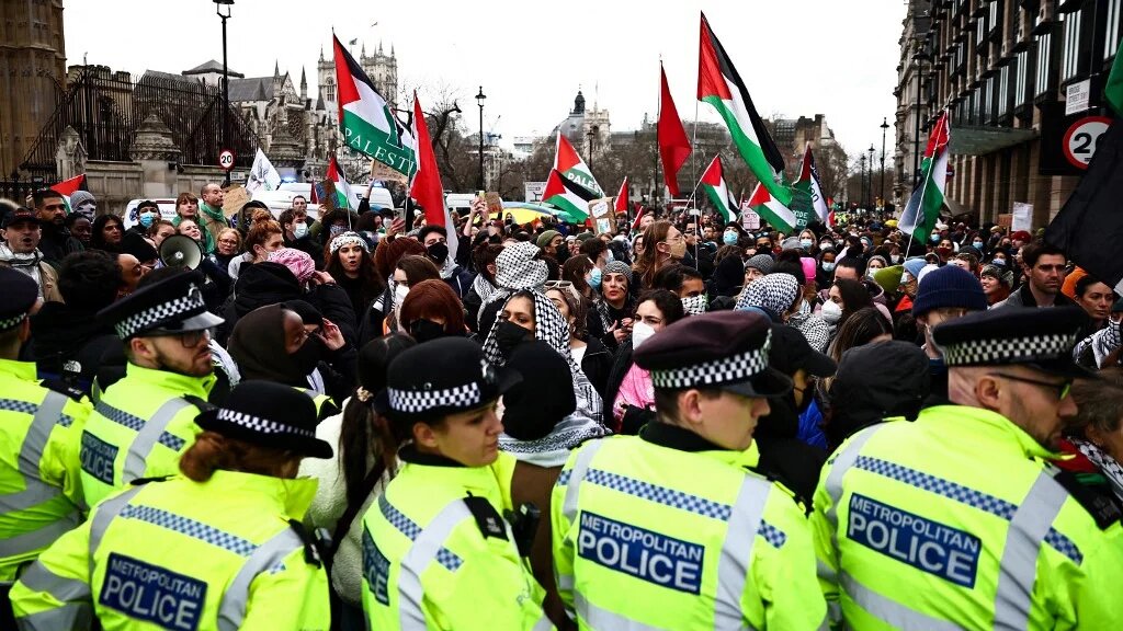 Police stand in front of pro-Palestinian protesters during a demonstration in central London on 6 January 2024 (Henry Nicholls/AFP)