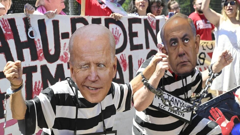 Activists wear masks depicting US President Joe Biden and Israeli Prime Minister Benjamin Netanyahu in Washington on 8 June 8 2024 (Mattie Neretin/Getty Images/AFP)