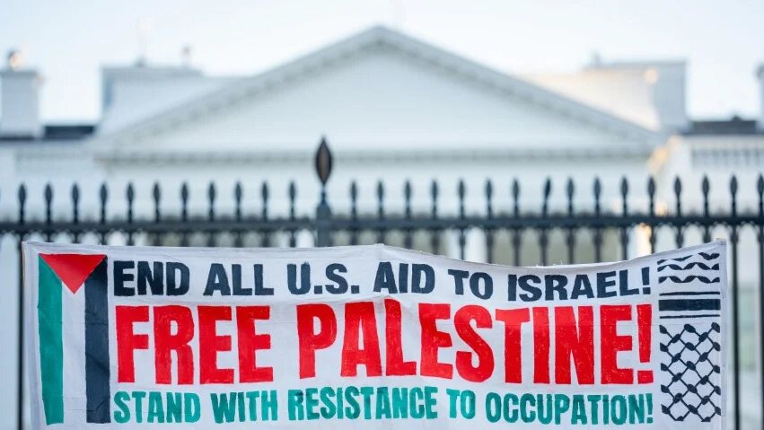 A protest sign denounces Israel’s bombing of Gaza, and US complicity in the war, outside the White House in Washington, DC, on 18 March 2025 (Andrew Harnik/Getty Images/AFP)
