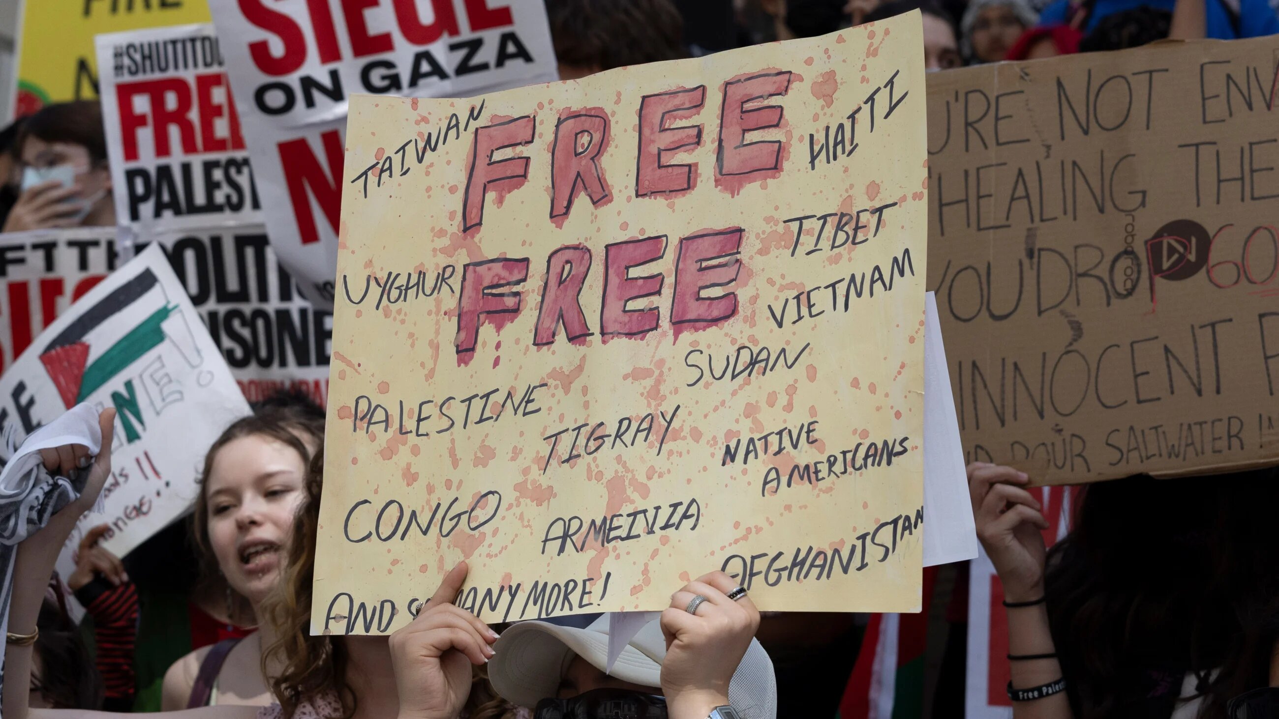 Protesters at a rally for Gaza hold signs urging global attention on Palestine and other conflicts in New York City on 31 May 2024 (Gina M Randazzo/Zuma Press Wire via Reuters)