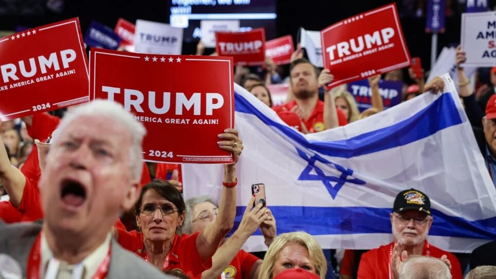 Attendees hold up an Israeli flag and Trump signs at the Republican National Convention in Milwaukee, Wisconsin, on 16 July 2024 (Joe Raedle/Getty Images/AFP)