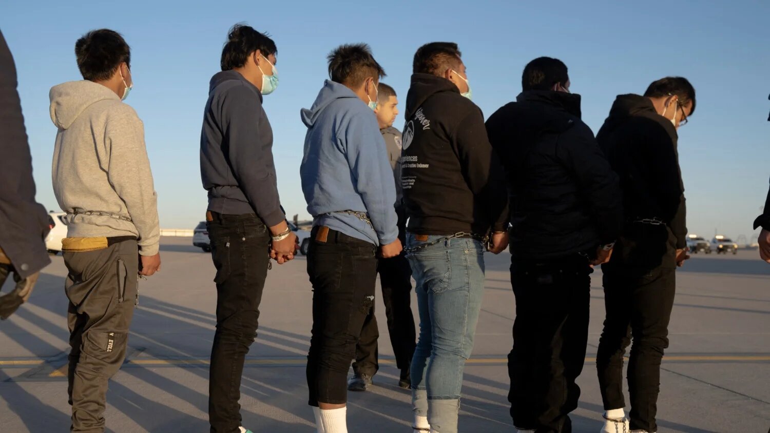 Undocumented migrants in shackles prepare to board a US military plane for a deportation flight at Fort Bliss, Texas, on 23 January 2025.
