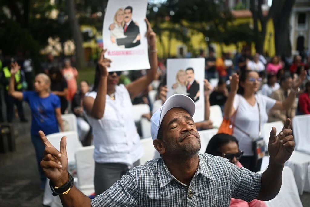 An Evangelical man prays during an event in support of deposed Venezuelan president Nicolas Maduro and his wife Cilia Flores, at Plaza Bolivar in Caracas on 11 January 2026 (AFP)