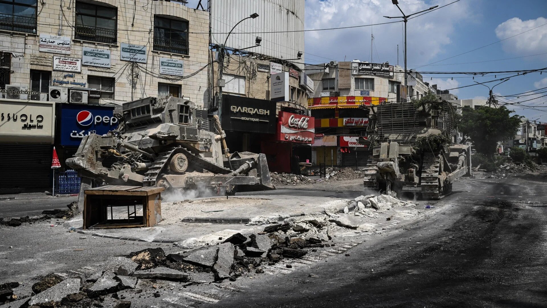 Bulldozers tear up a street during an Israeli raid in the centre of Jenin in the occupied West Bank on 2 September 2024 (AFP/Ronaldo Schemidt)