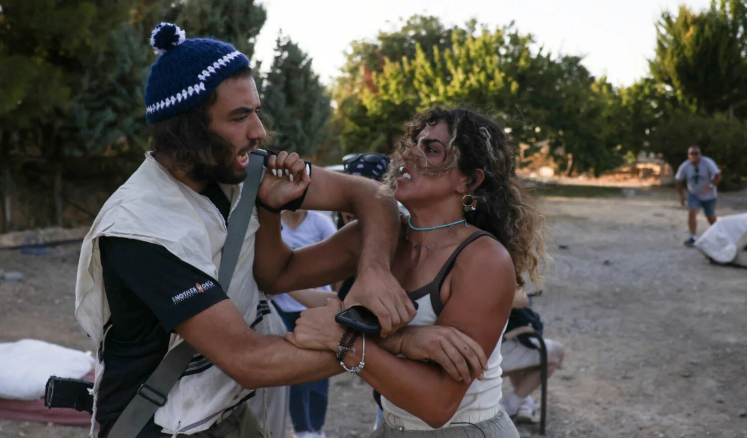 Palestinian Alice Kisiya (right), whose family land was taken over by armed Israeli settlers planning to build a new outpost, confronts a settler in al-Makhrour, occupied West Bank, on 22 August 2024 (AFP)