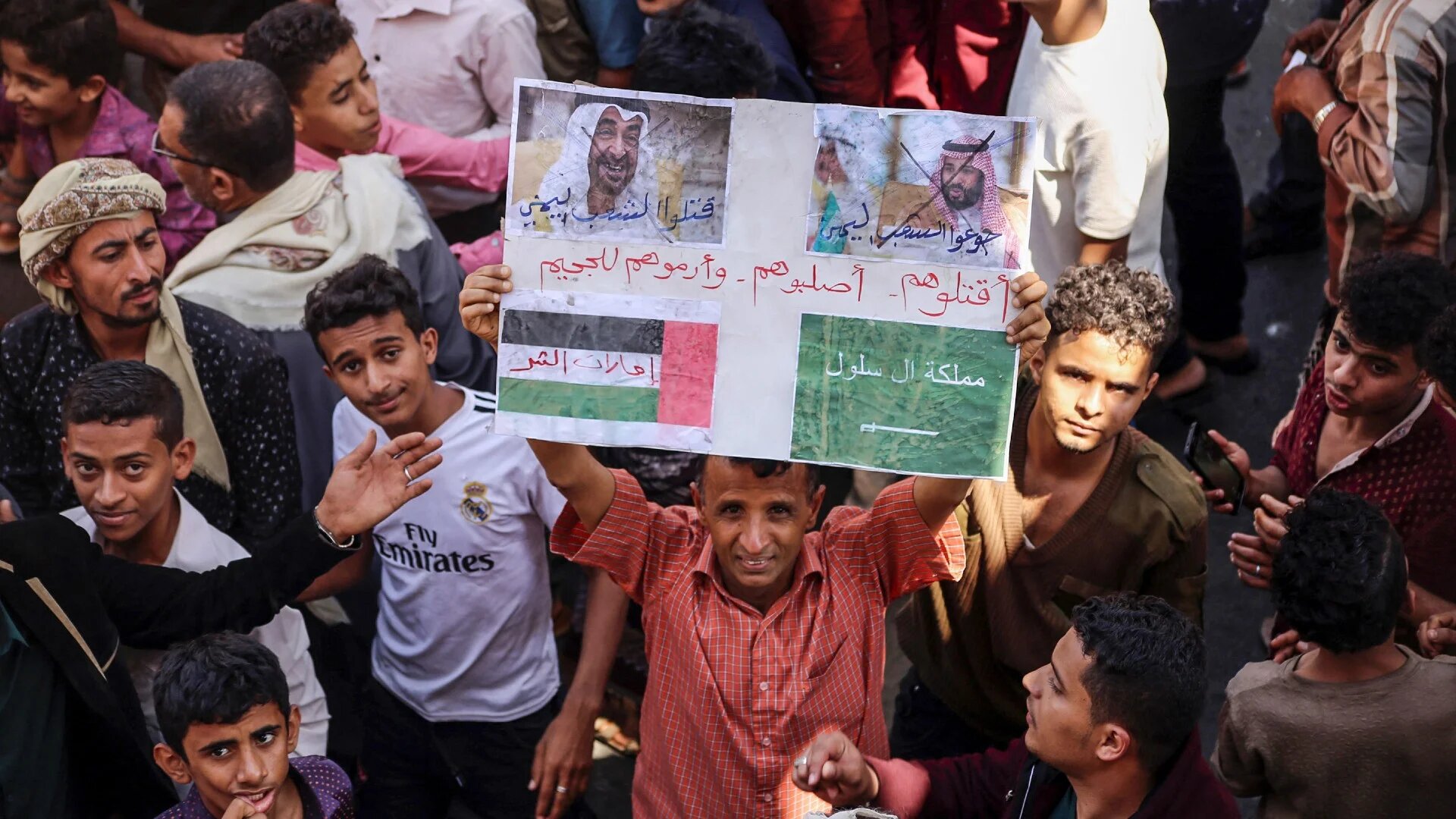 Un manifestant yéménite brandit une pancarte comportant les visages barrés du prince héritier saoudien Mohammed ben Salmane (à droite) et du président émirati Mohammed ben Zayed (à gauche) dans la ville yéménite de Ta’izz, le 4 octobre 2018 (AFP/Ahmad al-Basha)