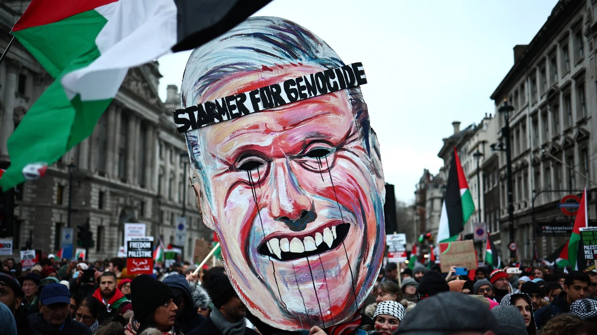 Pro-Palestinian activists carry a giant mask of Labour Party leader, Keir Starmer, during a march for Palestine in central London on 13 January 2024 (Henry Nicholls/AFP)
