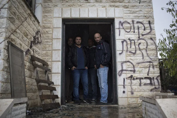 The Hebrew writing reads 'revenge the blood of yourֿ servants' on the wall of a home attacked by petrol bombs in the village of Khirbet Abu Fala, northeast of Ramallah on 23 November, 2014 (MEE/Oren Ziv)