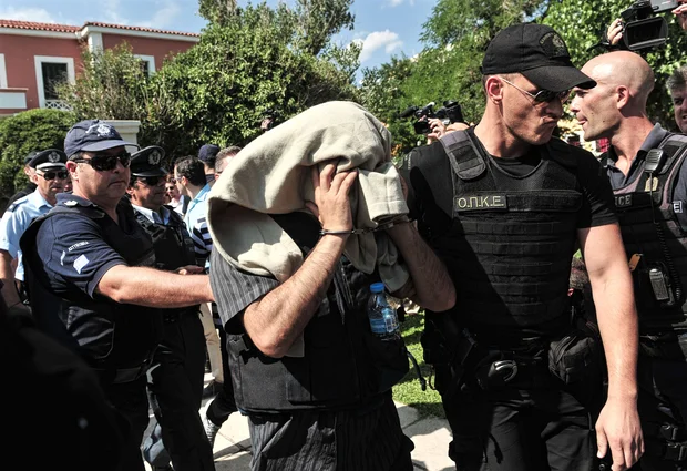 Greek police escort a Turkish officer who fled to Greece by helicopter after the failed coup (Sakis Mitrolidis/AFP)