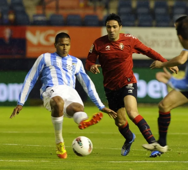 Osasuna's Iranian midfielder Javad Nekounam (R) vies with Malaga's Brazilian defender Weligton (L) during the Spanish league football match in Pamplona on 23 April, 2012 (AFP)