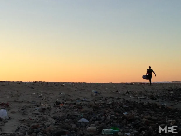 A kiter carrying his board along the shoreline at sunset (MEE/Tom Wescott)