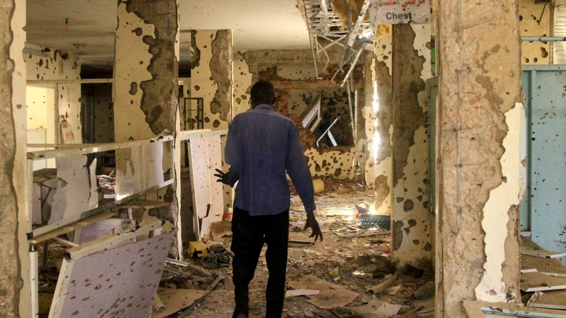 A man walks in the shrapnel-riddled ward of a hospital in Khartoum on 28 April 2025 (AFP)