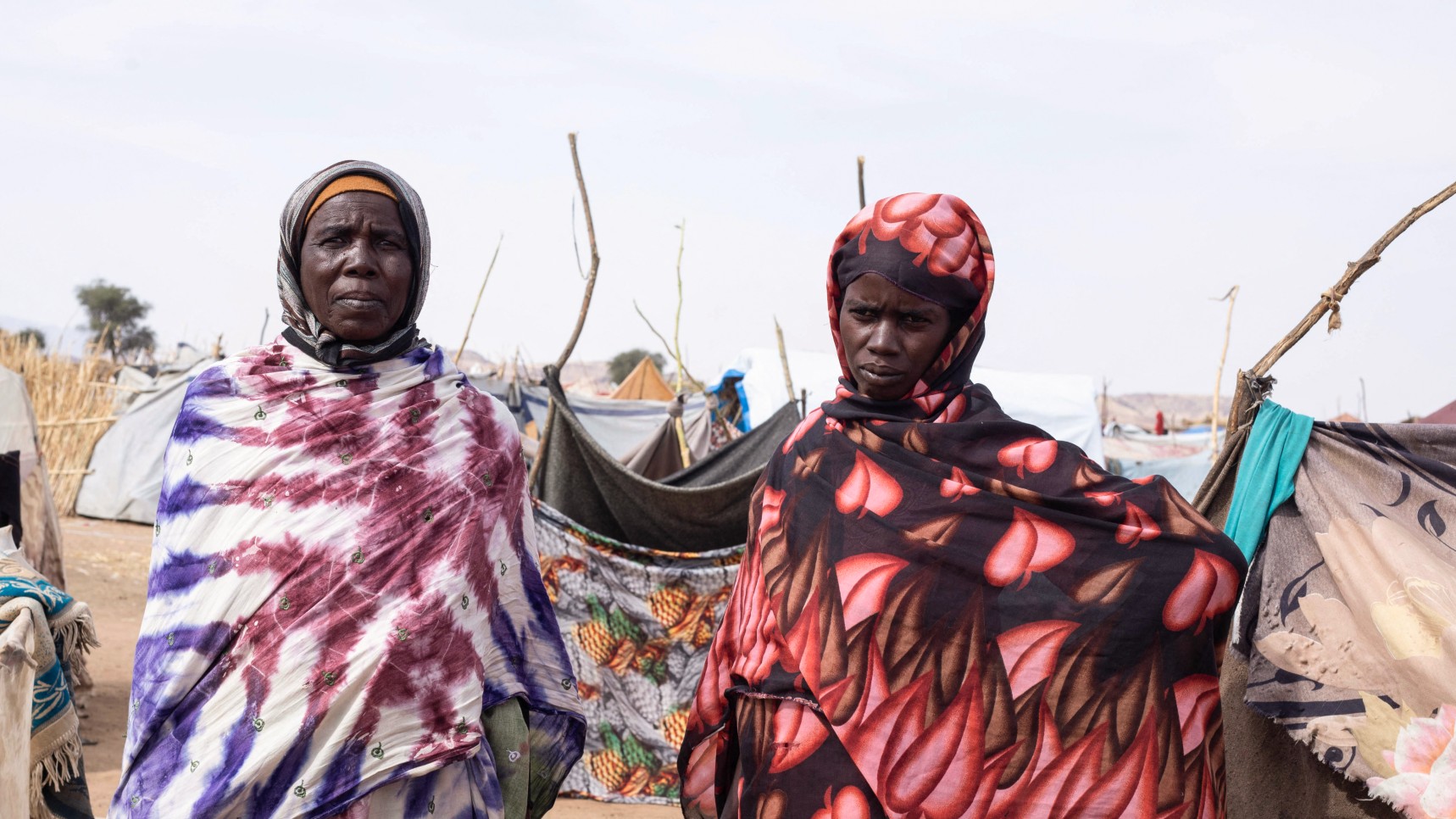 Sudanese women who fled el-Fasher stand in front of their makeshift shelter on the southwestern edge of Tawila, in war-torn Sudan's western Darfur region on 3 November  2025 (AFP)