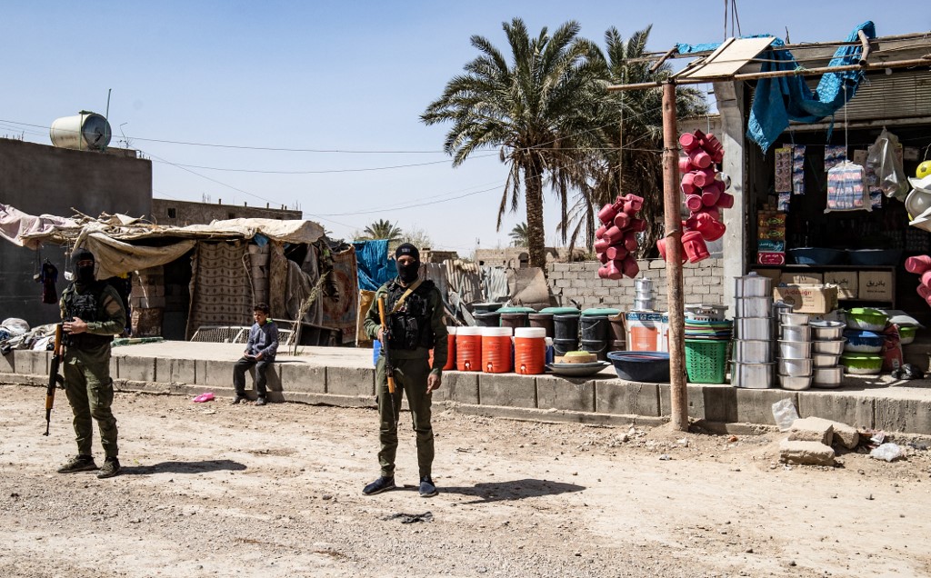 Fighters of the Kurdish-led Syrian Democratic Forces (SDF) stand guard in the village of Baghouz in Syria's northern Deir Ezzor province, on March 24, 2021, where two years ago, the Islamic State Group (IS) made their last stand before being defeated