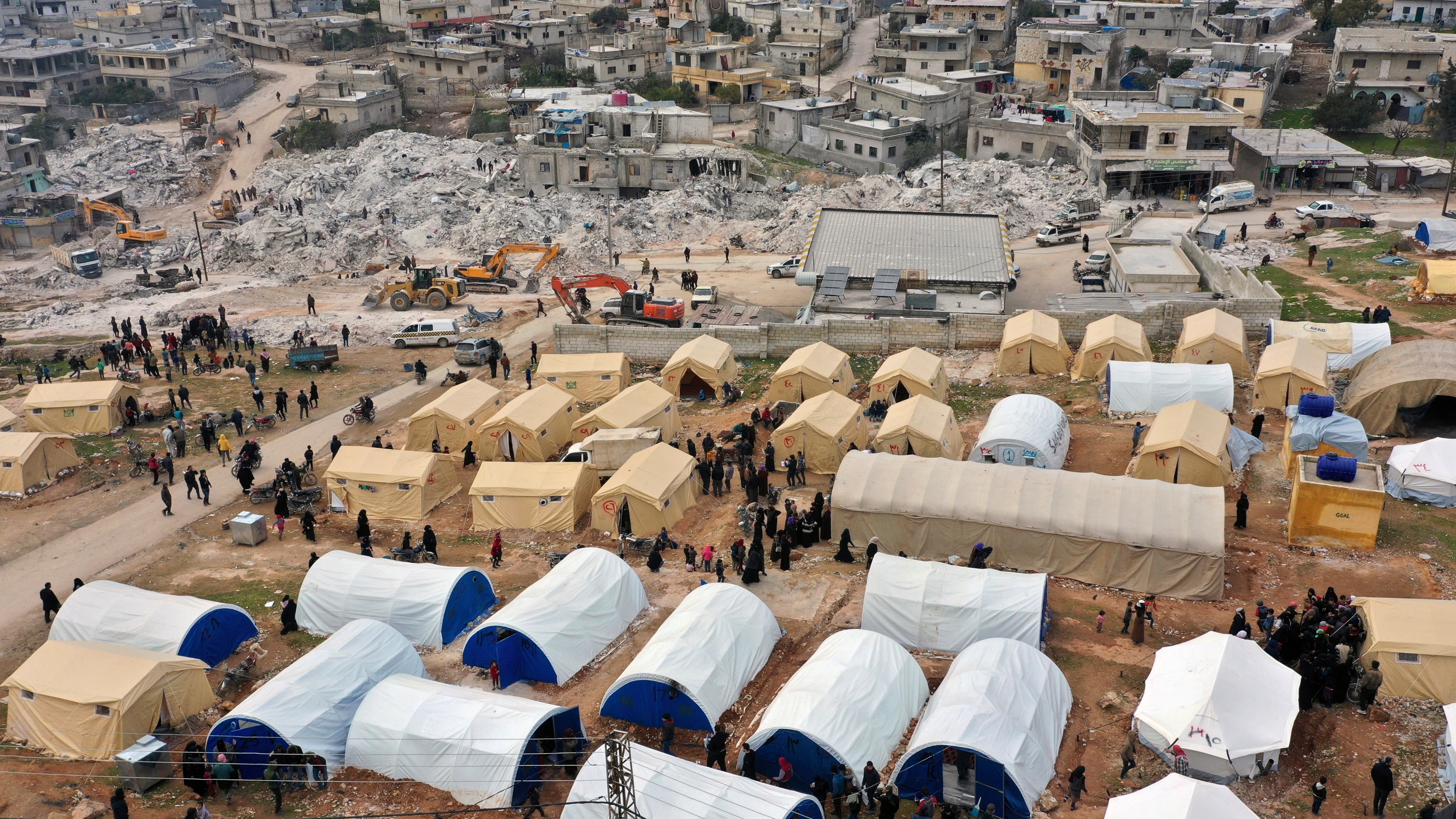 Volunteers set up tents for Families who lost their homes in a devastating earthquake to provide them shelter and food near destroyed buildings in the town of Harem, Idlib province, Syria, Saturday, Feb. 11, 2023