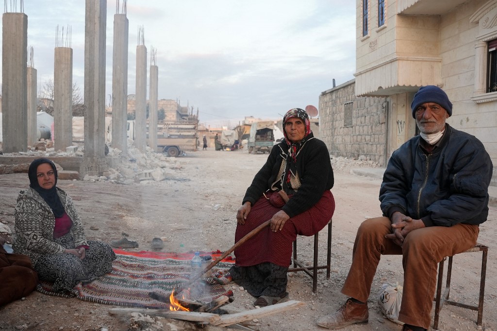 Syrians gather in a street after the earthquake in Jindayris on 14 February 2023 (AFP)