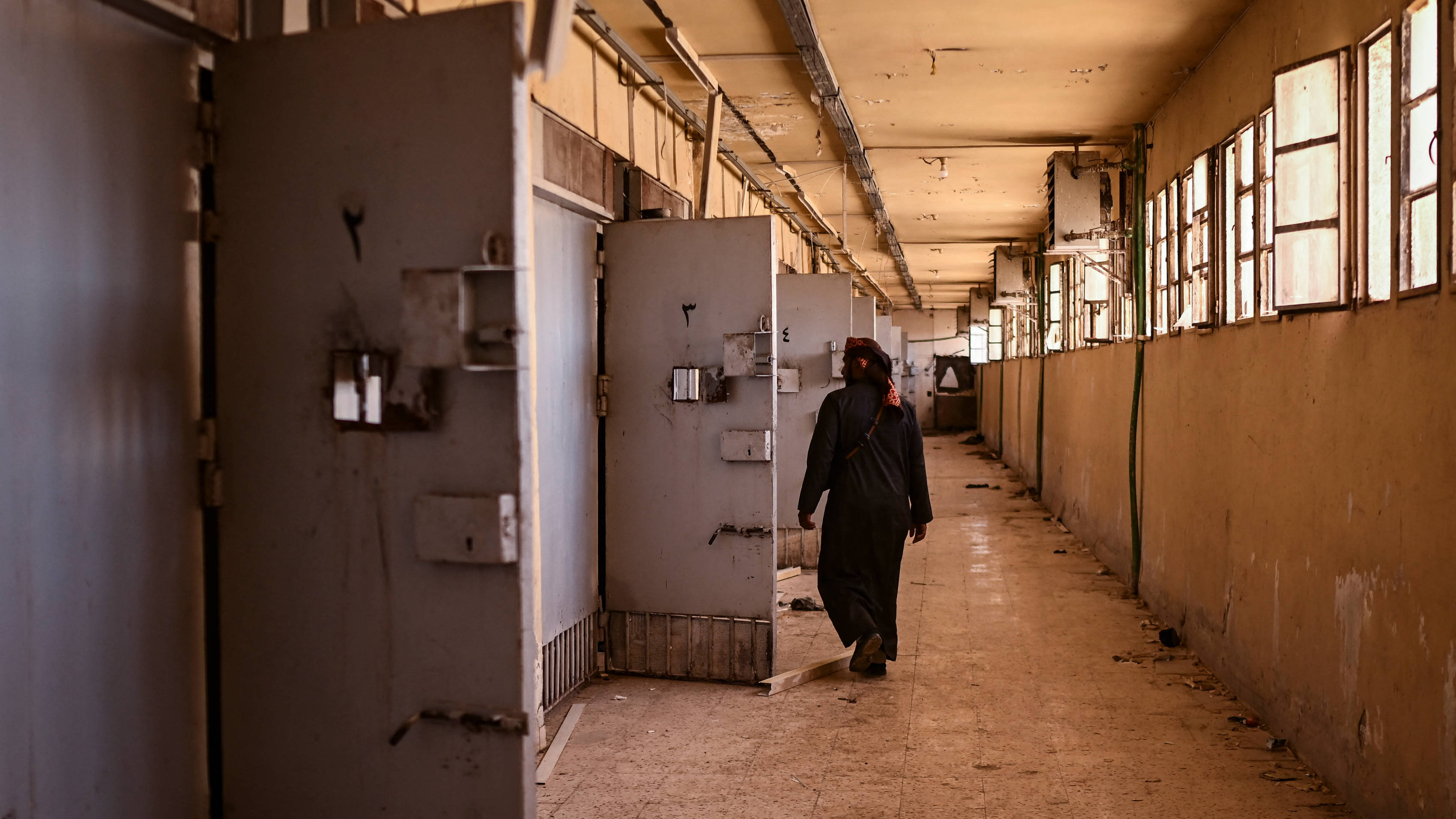 A man walks past empty cells at the Saydnaya prison, north of the Syrian capital Damascus, on 15 December 2024 (AFP)