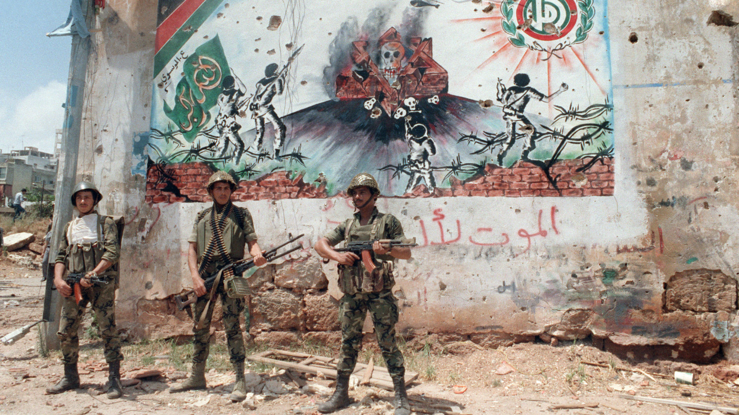Syrian soldiers patrol in a southern suburb of Beirut 27 May 1988, in front of an Amal frescoes, after heavy clashes erupted between the Amal movement and Hezbollah (AFP)