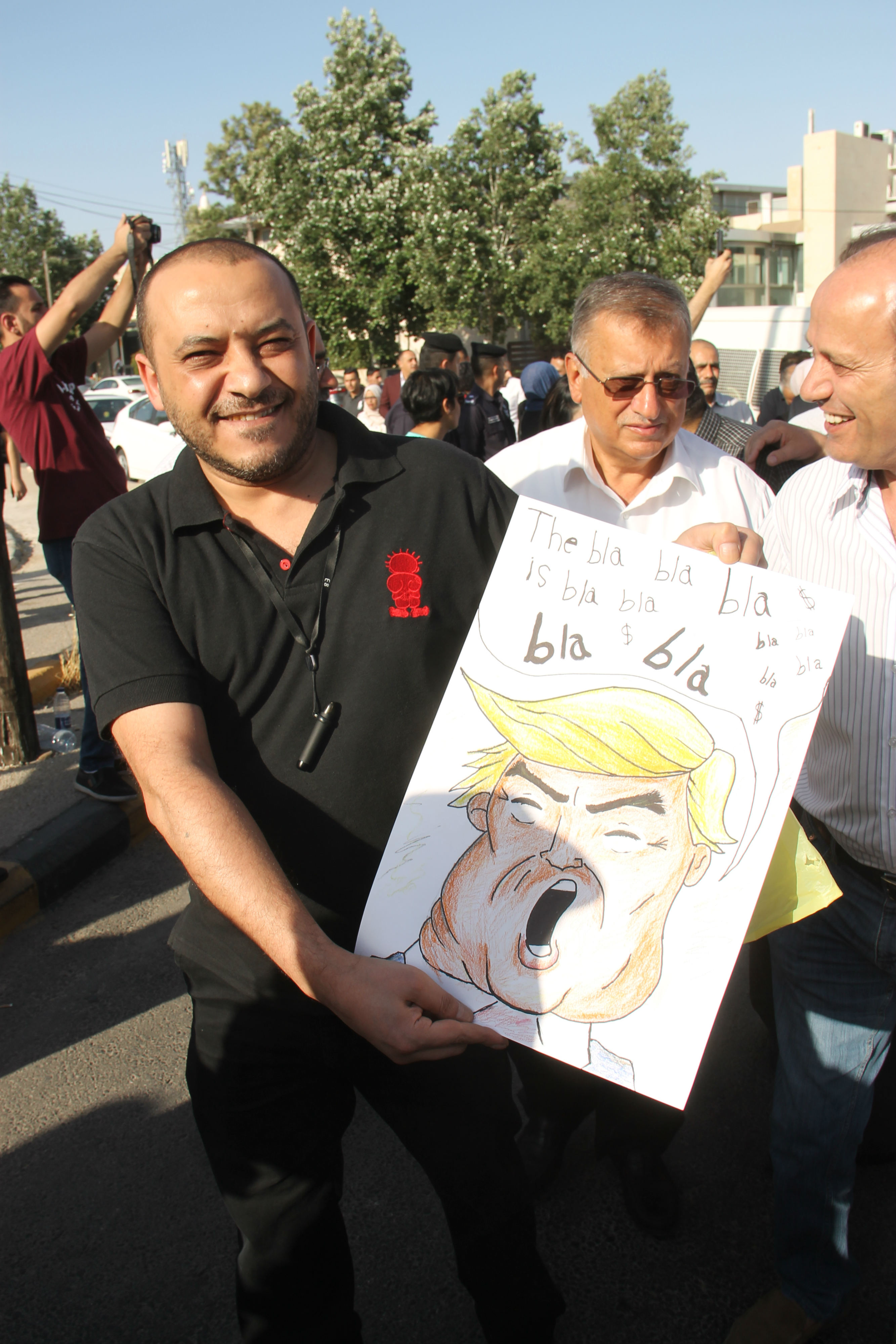 A protester holds an image of Donald Trump at a rally against his 