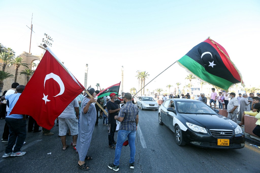 People wave Libyan and Turkish flags during a demonstration in Tripoli on 21 June (AFP)