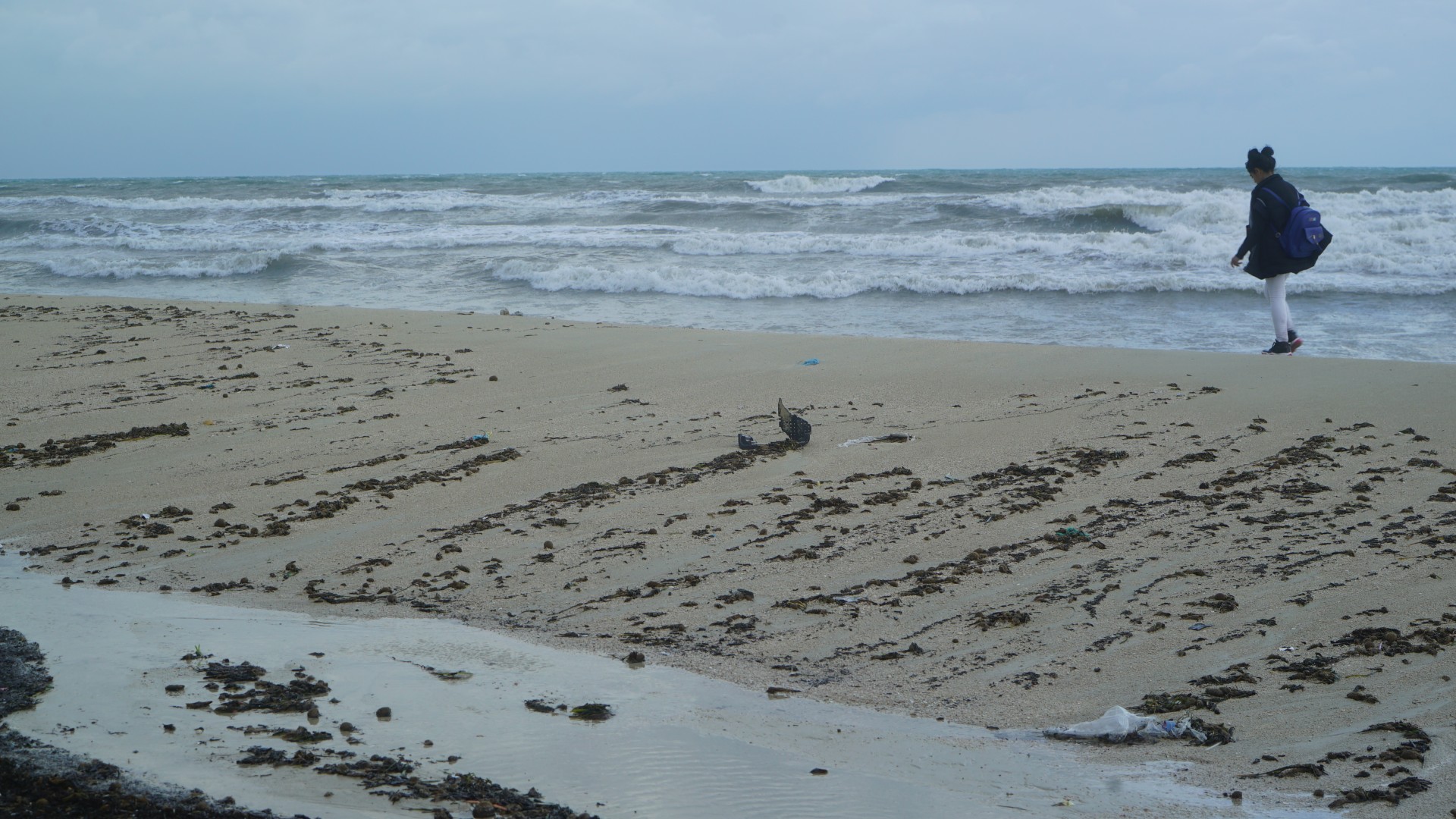 A young Tunisian girl walks along the beach in Zarzis, a small coastal town used by migrants to take boat journeys to Europe (MEE/Faisal Edroos)