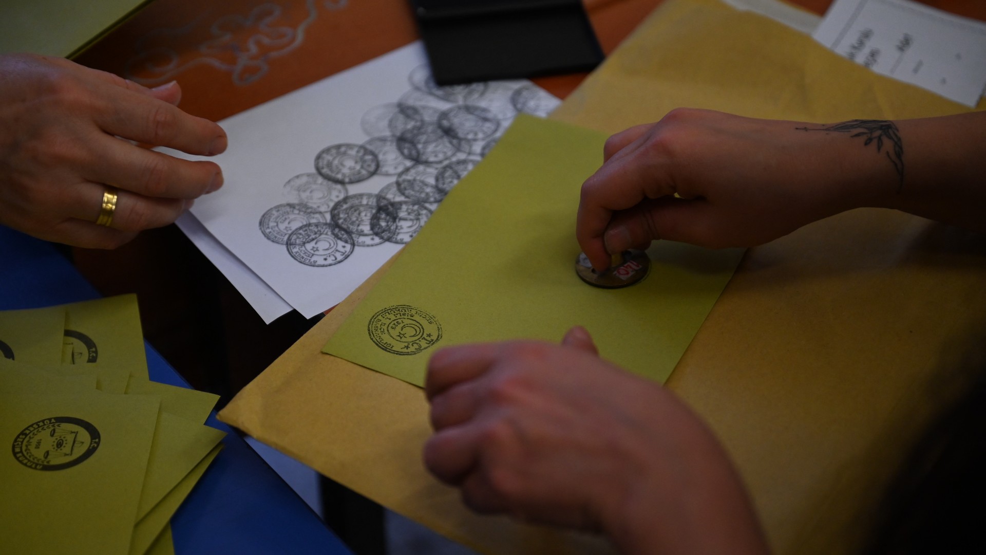 Election officials prepare ballot papers at a polling station during the presidential elections in Istanbul on 28 May 2023 (AFP)