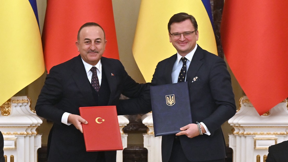 Ukraine's President Volodymyr Zelensky (R) and his Turkish counterpart Recep Tayyip Erdogan (L) applaud as Foreign Minister of Ukraine Dmytro Kuleba (2R) and his counterpart Mevlut Cavusoglu (2L) exchange folders with signed documents in Kyiv on February 3, 2022. 