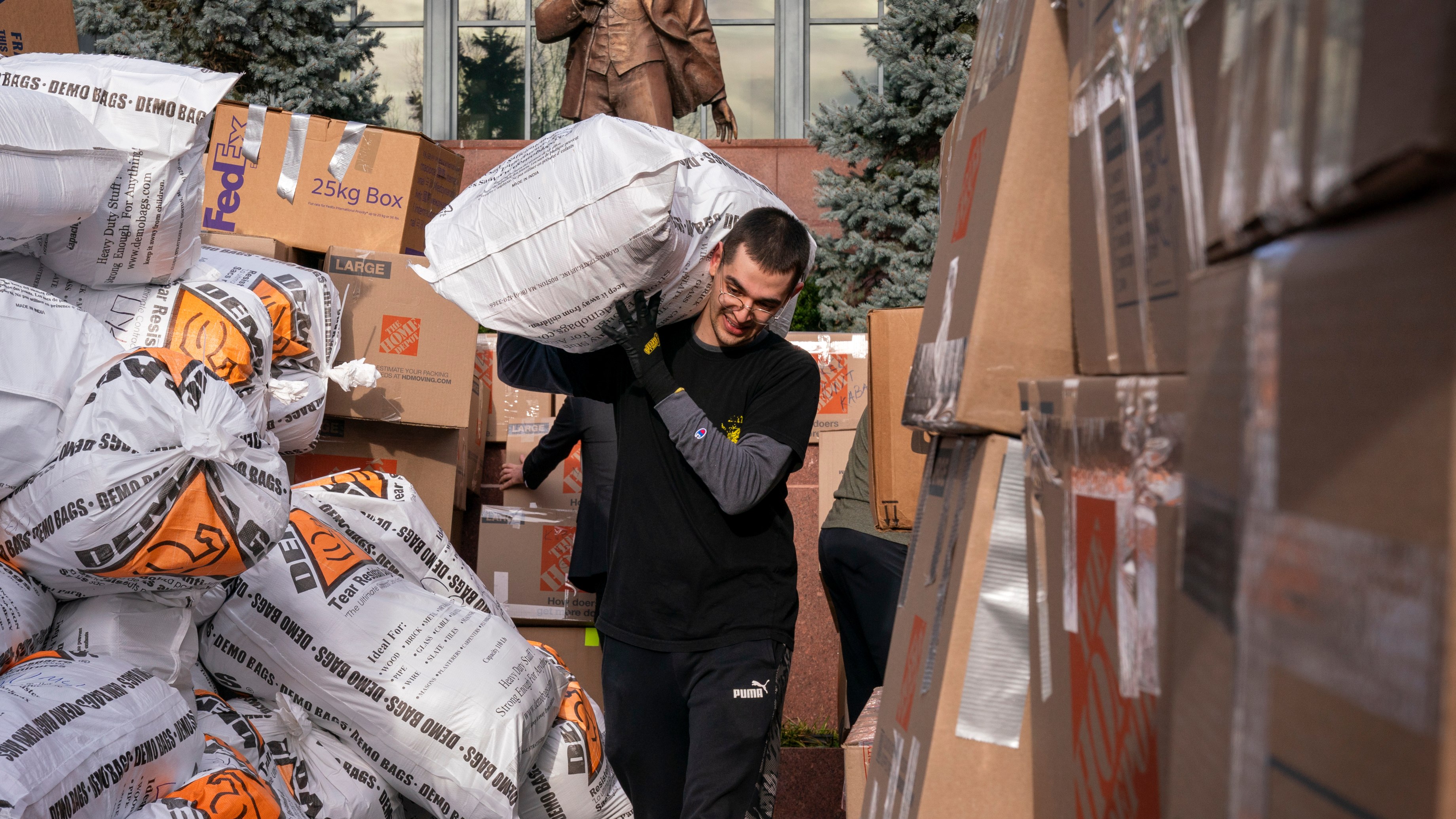 A volunteer walks through a corridor formed by sorted donations for earthquake victims, Friday, Feb. 10, 2023, at the Turkish Embassy in Washington.