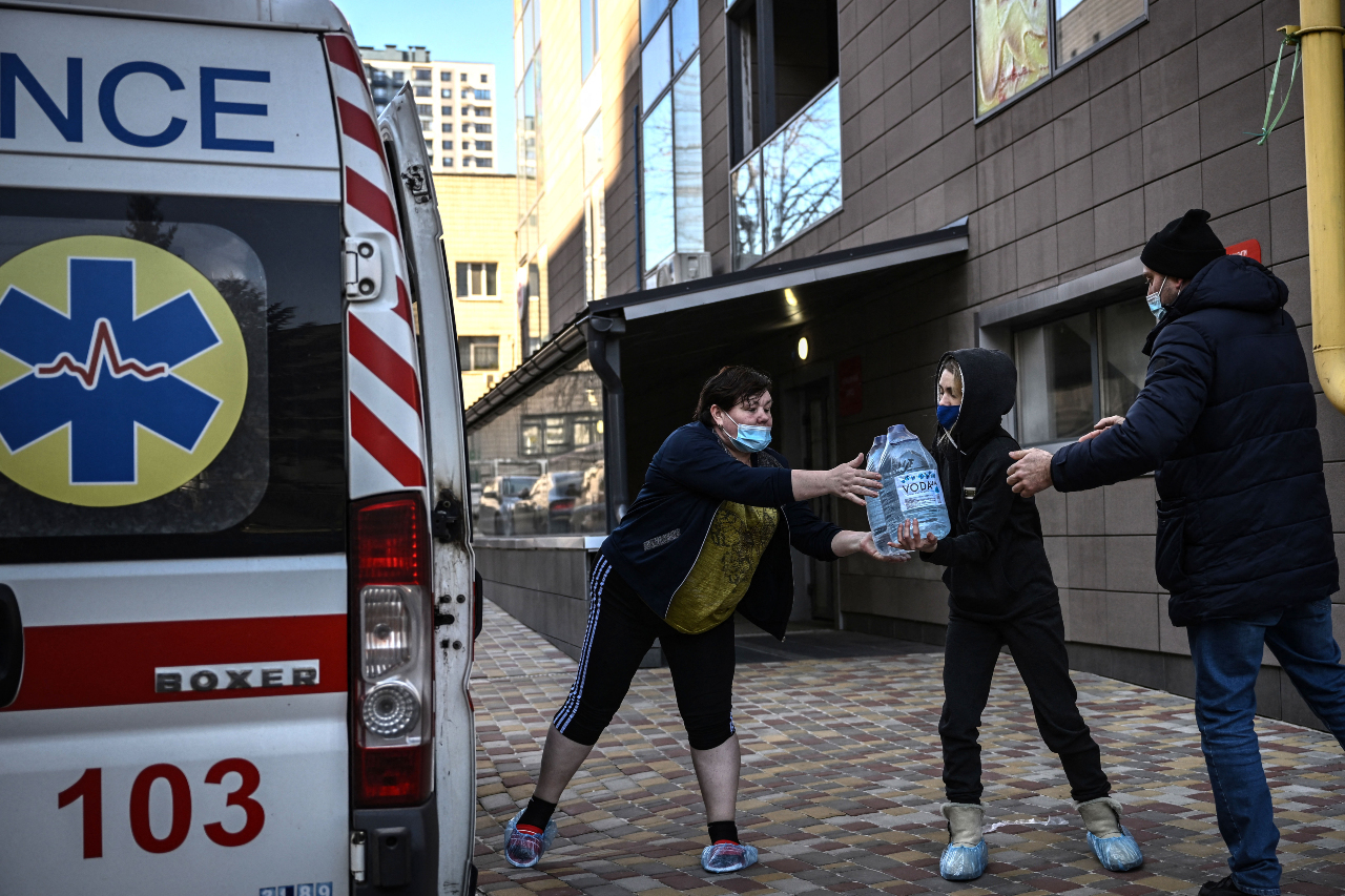 People unload water from an ambulance at the pediatric hospital in Kyiv on 28 February 2022