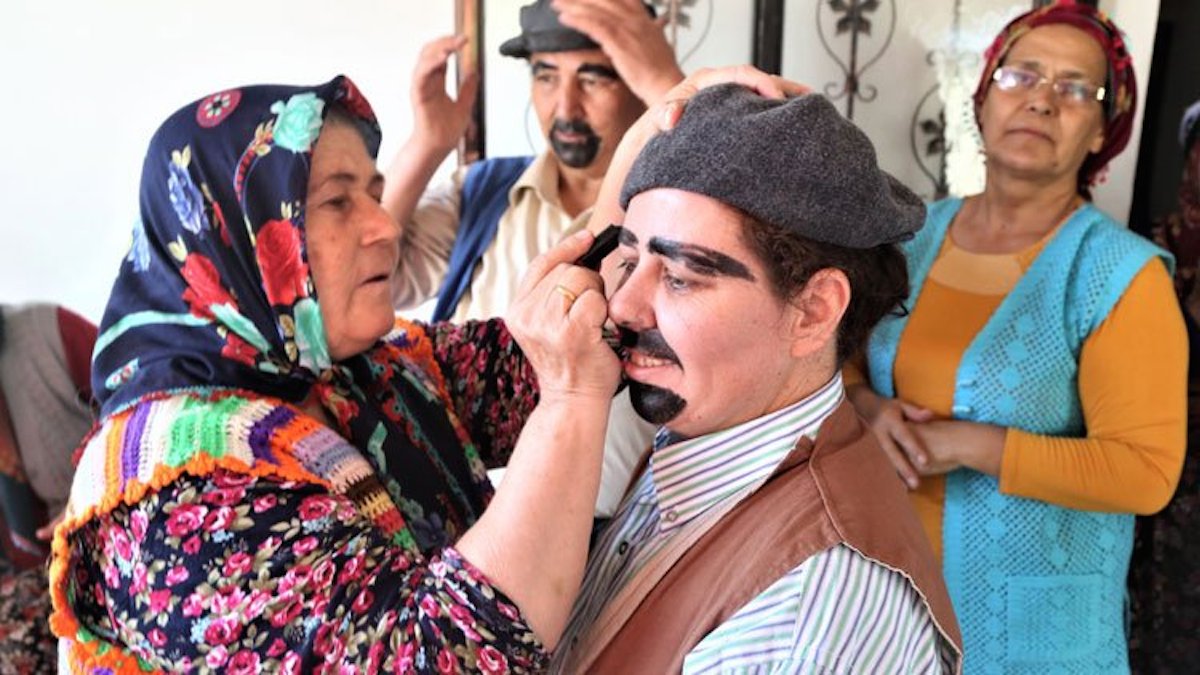 Kocak applies the boot polish makeup that the theatre group use in their plays (Umiye Kocak)