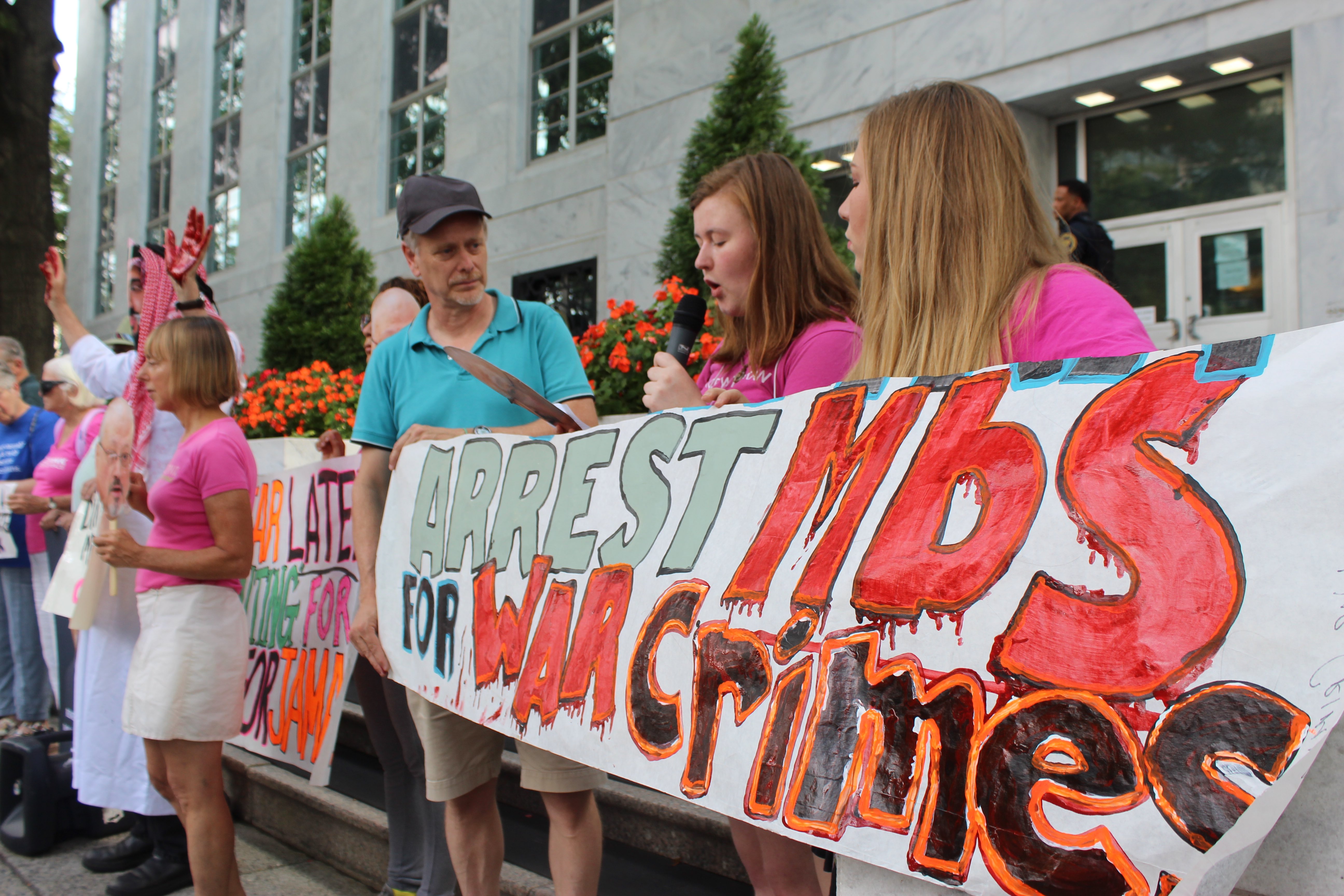 Members of Code Pink lead chants and hold a sign that reads: 
