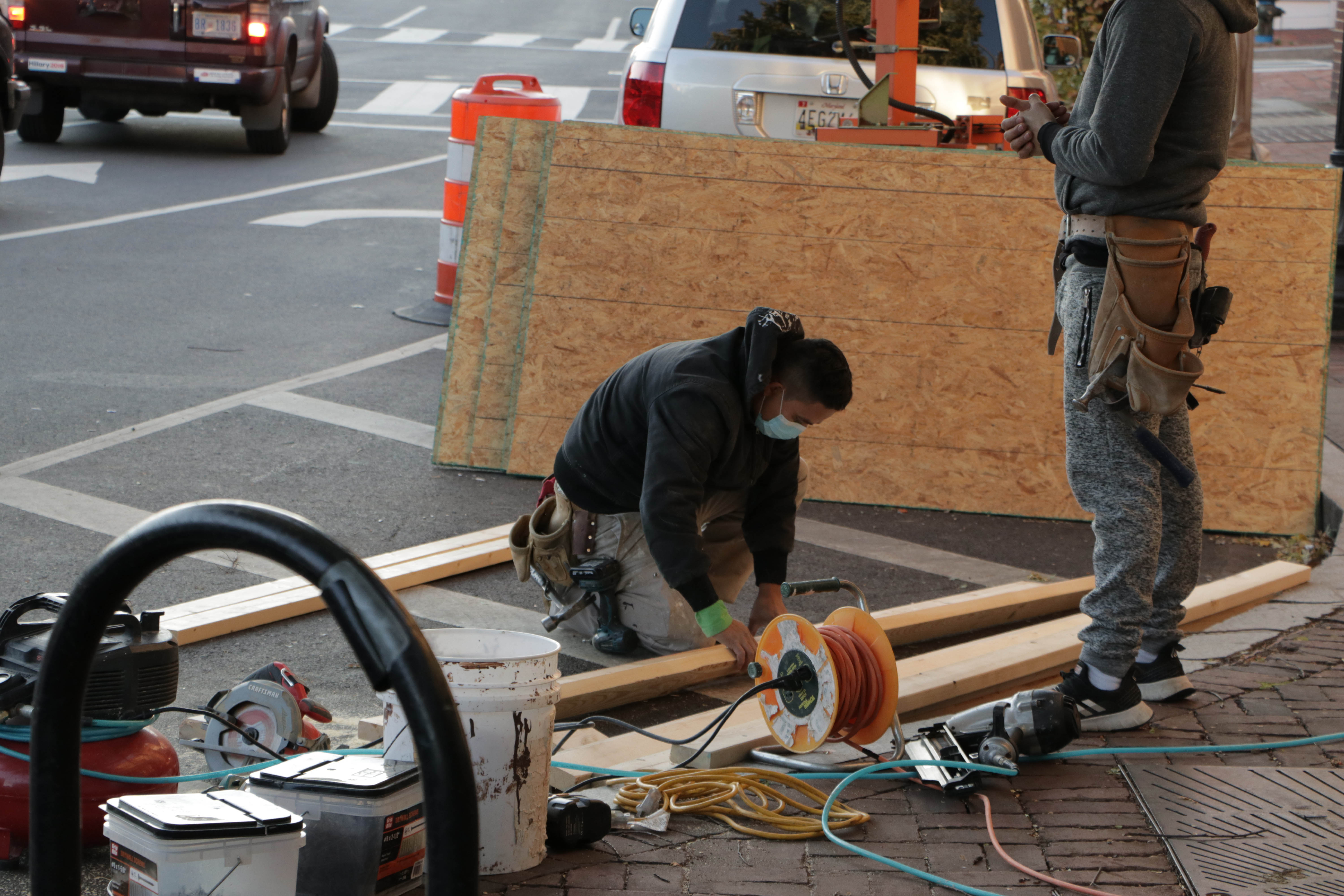 A worker trims plywood pieces to be boarded up on a CVS pharmacy in Georgetown.