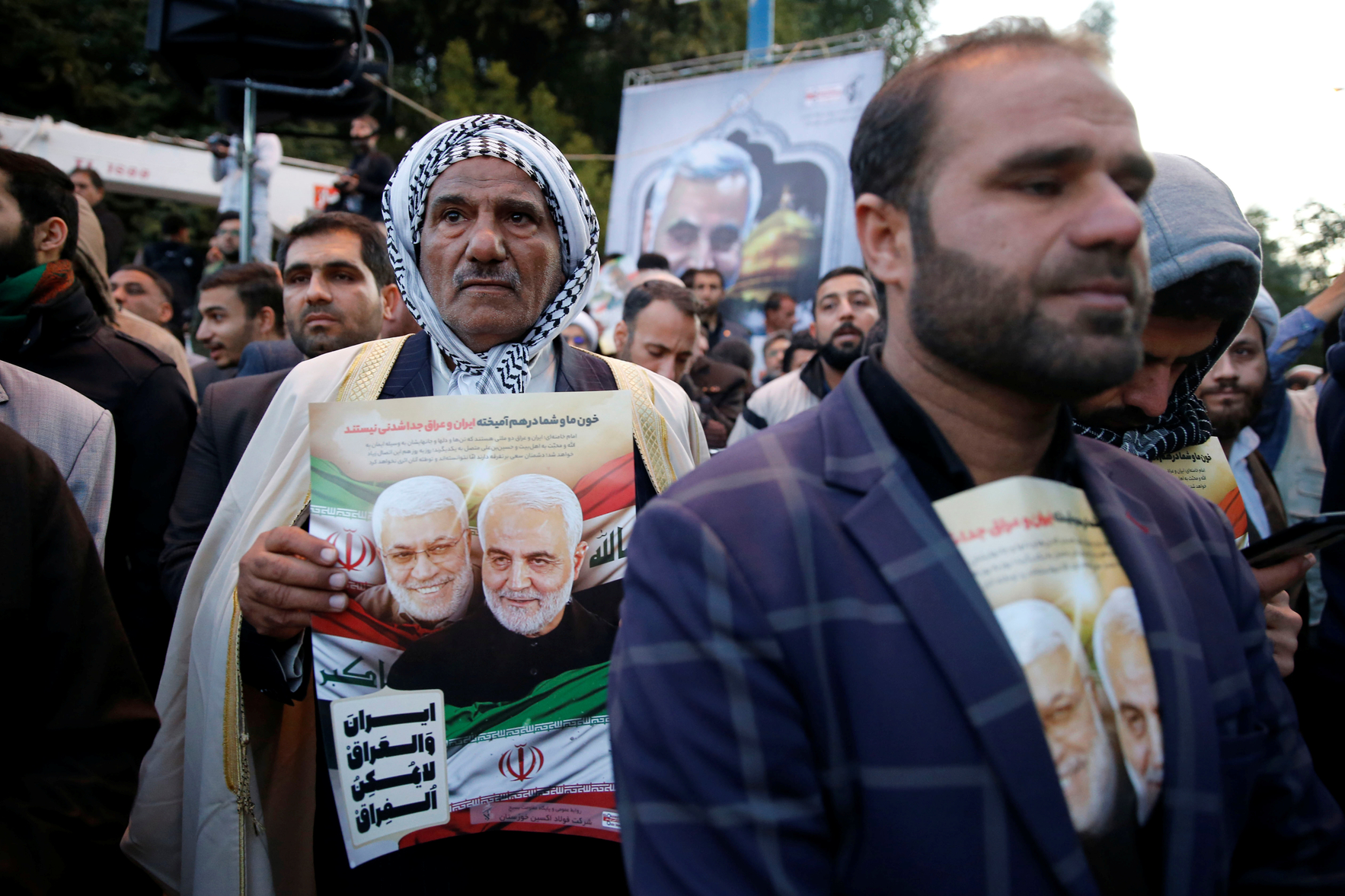 Man holds portrait of Qassem Soleimani during a funeral procession in Ahvaz (Reuters)
