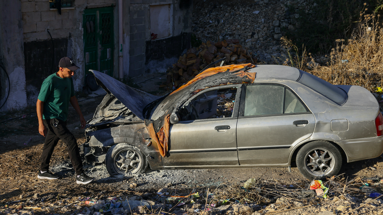 Palestinian man inspects a burnt car after it was torched in an attack carried out by Israeli settlers in the Israeli-occupied West Bank city of Hebron, 20 September 2026. (AFP/Hazem Bader)