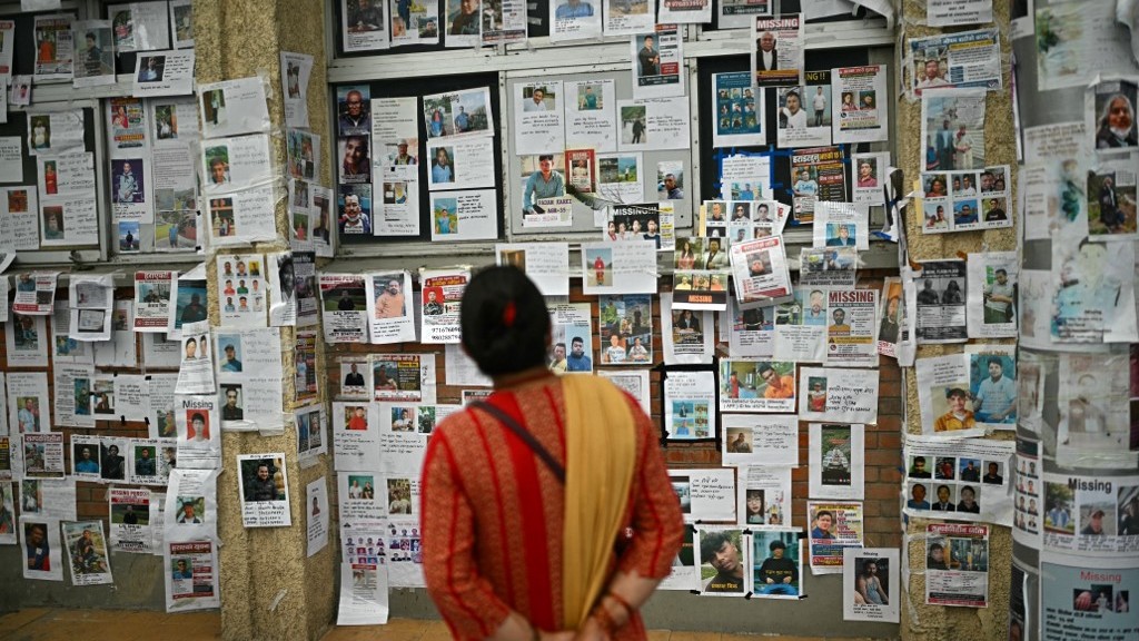 Woman looks at photographs outside a morgue in Kathmandu on September 7 following the flash floods that swept through Nepal's Nuwakot district (AFP/Pedro Pardo)