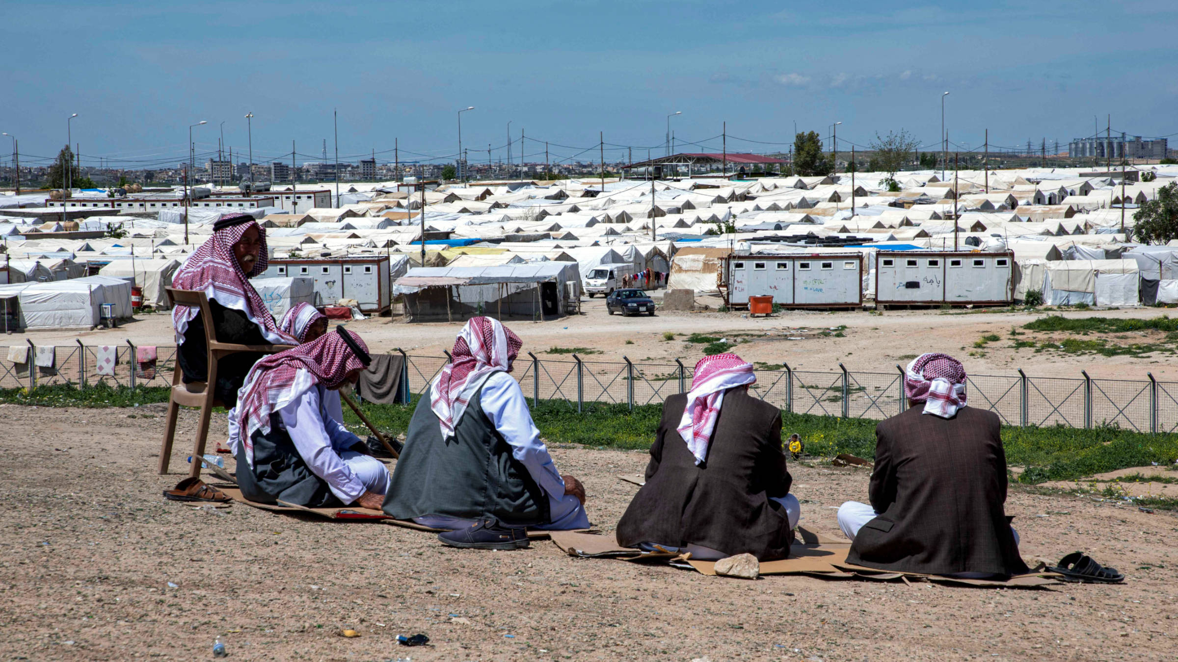 In this picture taken on 22 April  2023, displaced Iraqi men from the Yazidi community sit outside at the Sharya camp, some 15 kilometres near the northern Iraqi city of Dohuk (AFP)
