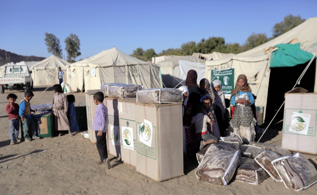 Displaced Yemenis receive humanitarian aid at a camp in Yemen's northeastern province of Marib on 26 January 2018. (AFP)