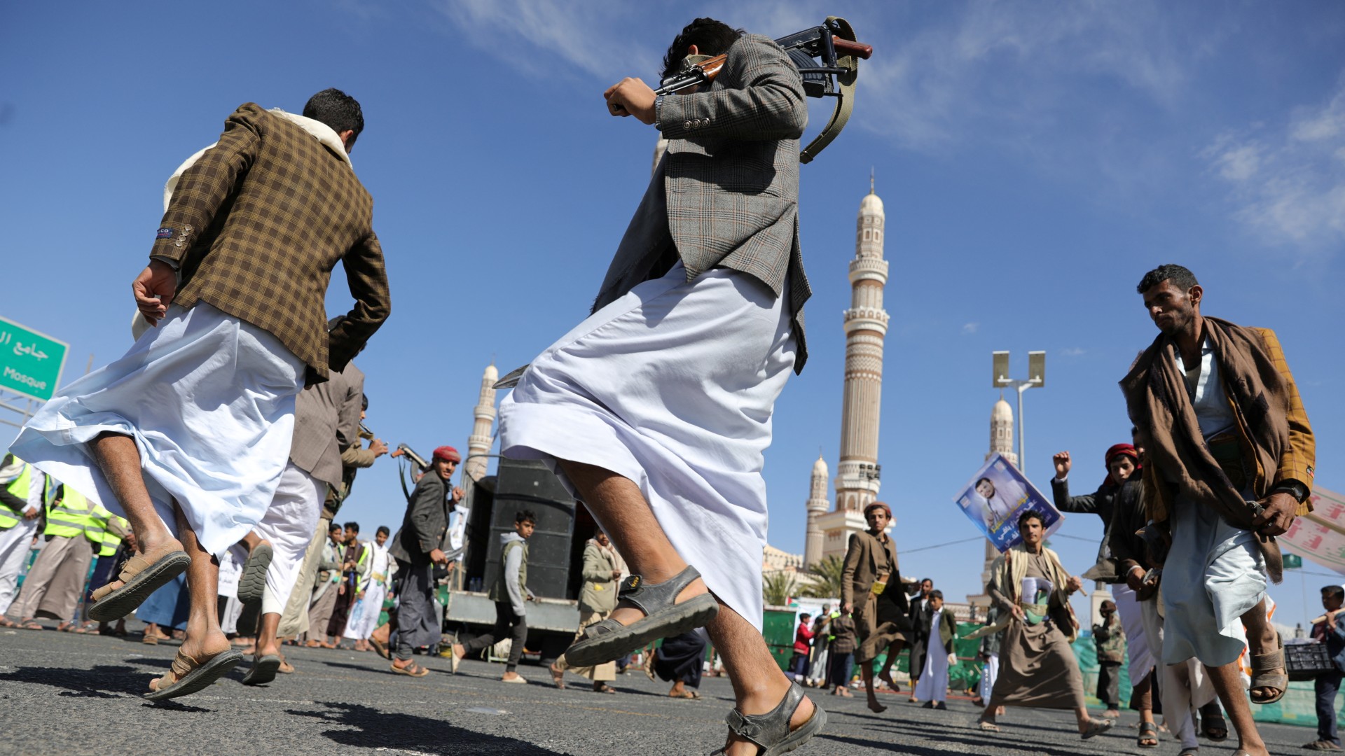 Yemenis perform a traditional dance near the iconic Great Mosque of Sanaa at a protest in solidarity with Palestinians in Gaza on 2 Feb 2024 (Reuters)