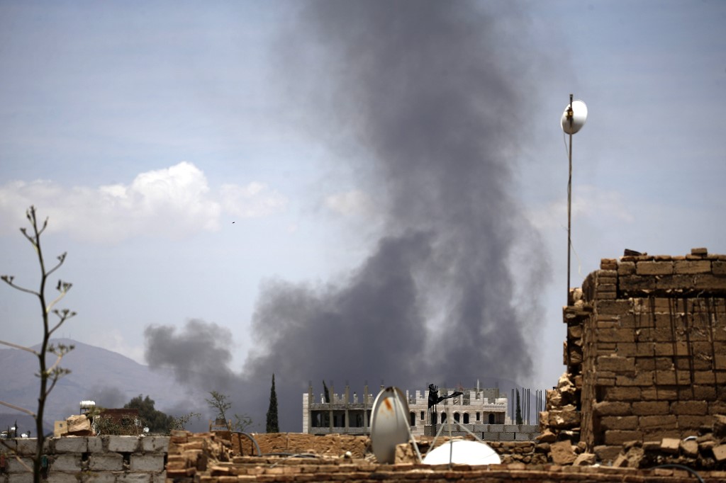 Smoke billows after an air strike by the Saudi-led coalition in Sanaa in 2018 (AFP)
