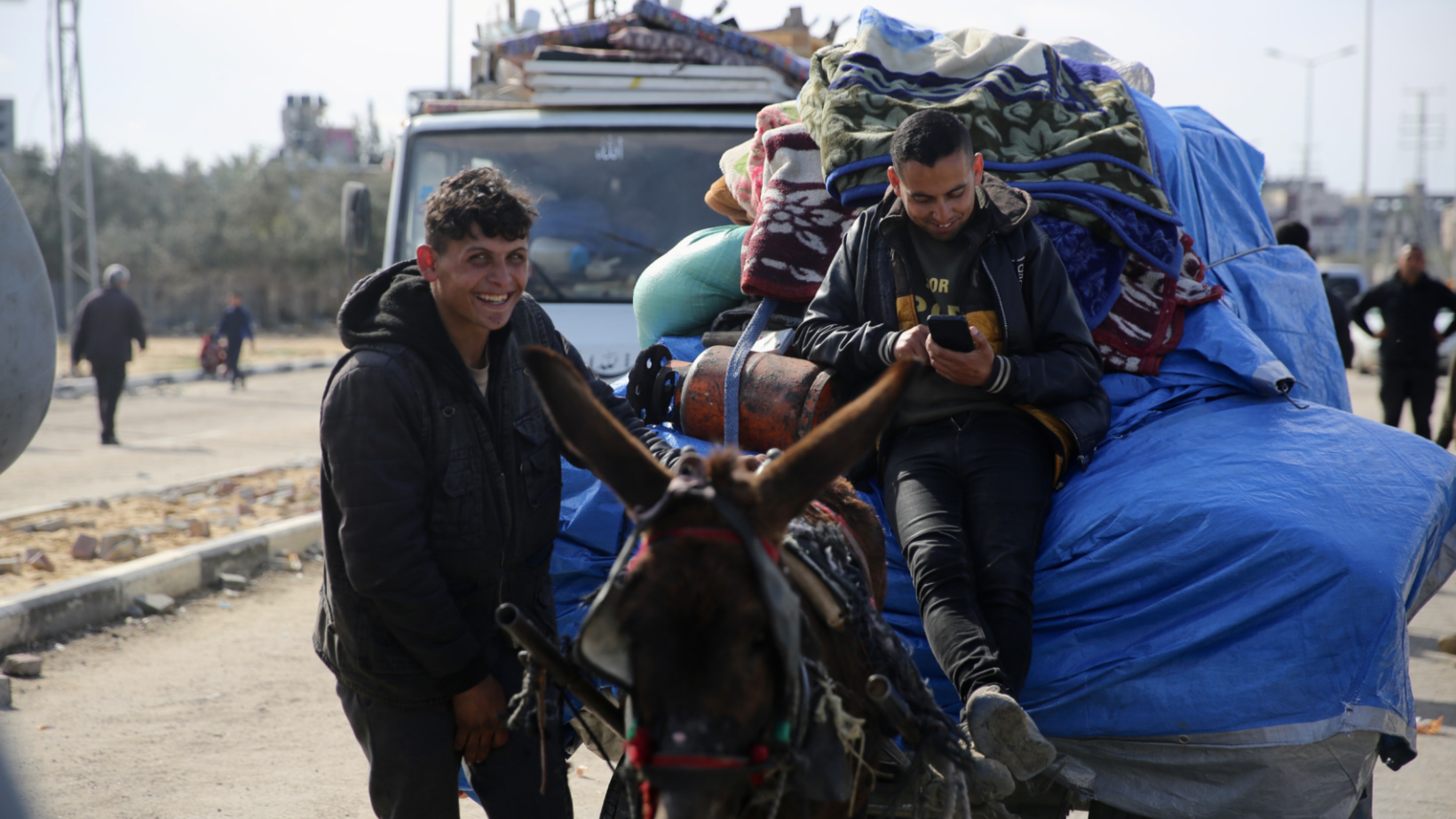 Young men wait with their donkey to be allowed back in north Gaza near the Netzarim corridor on 25 January 2025 (Mohammed al-Hajjar/MEE)