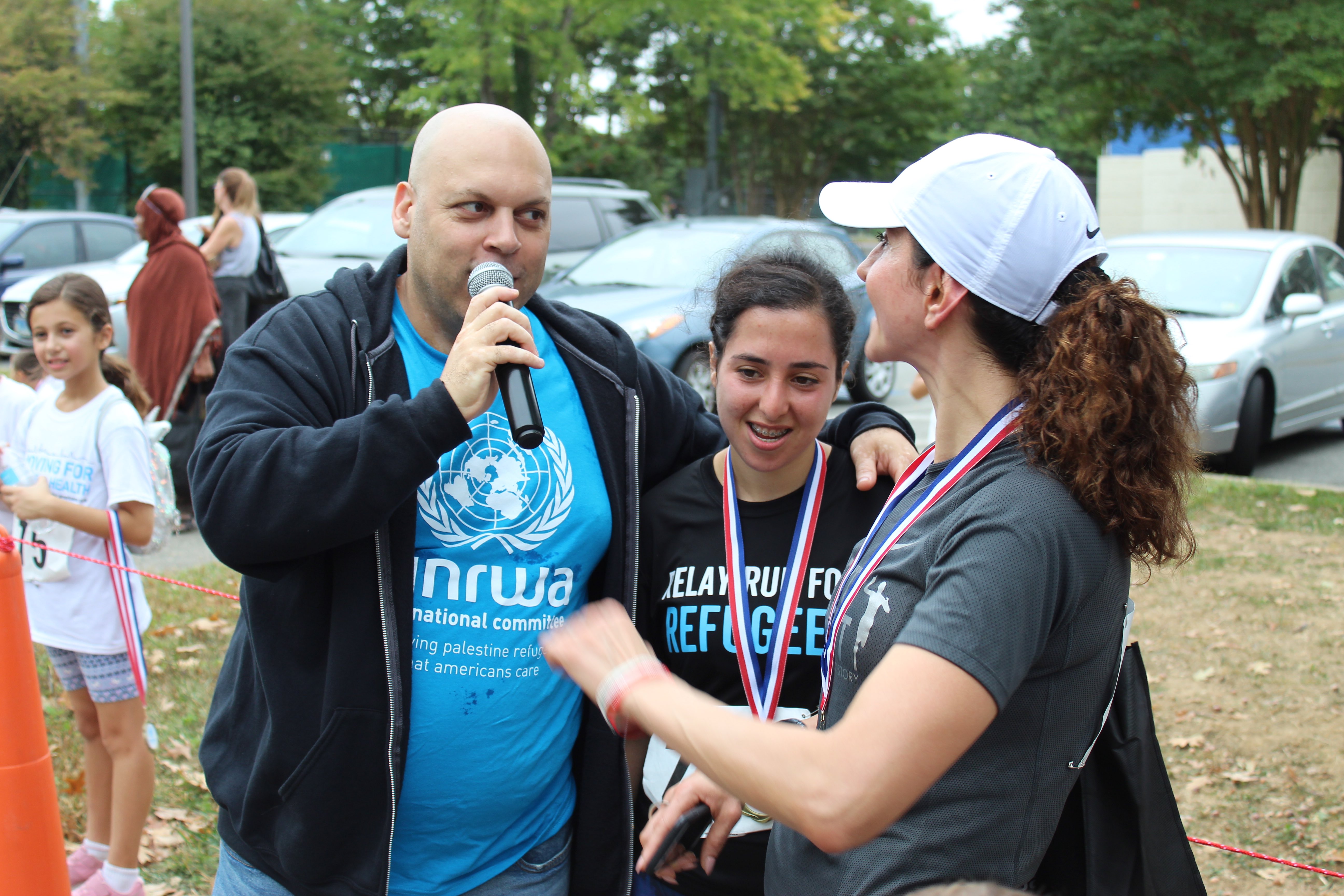Amer Zahr speaks to one of the runners, entertaining the crowd while everyone awaits the rest of the participants at the finish line (MEE/Sheren Khalel) 